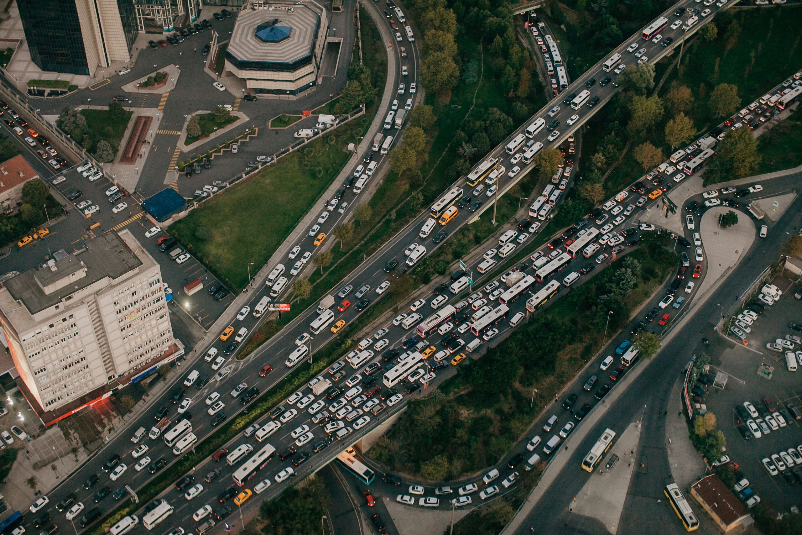 Vista aérea de un cruce vial con cientos de autos en circulación, escala del parque vehicular que sustenta el análisis de datos automotrices en México, tratamiento de marca en tono azul